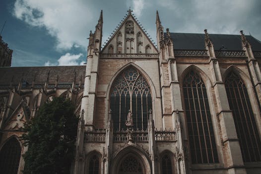 从低角度拍摄的雄伟哥特式大教堂立面，在多云的天空下展现出复杂的建筑细节