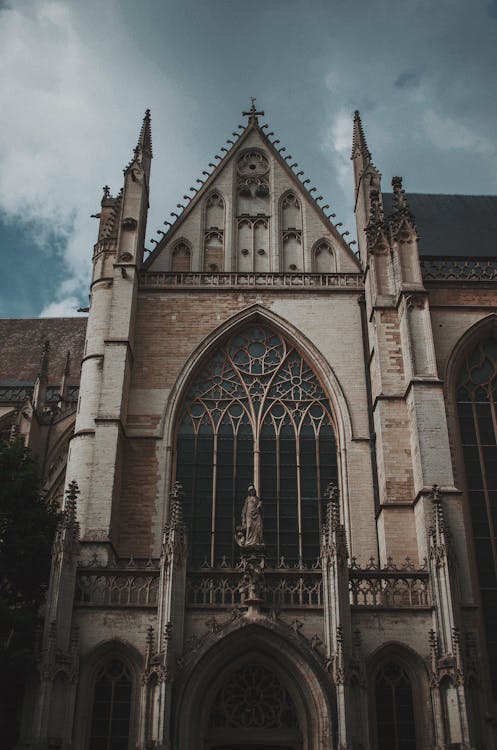 Free Low-Angle Photo of Church Under Cloudy Sky Stock Photo