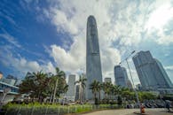 在阴云密布的天空下，从低角度欣赏香港标志性的摩天大楼，展现了城市与建筑的优雅