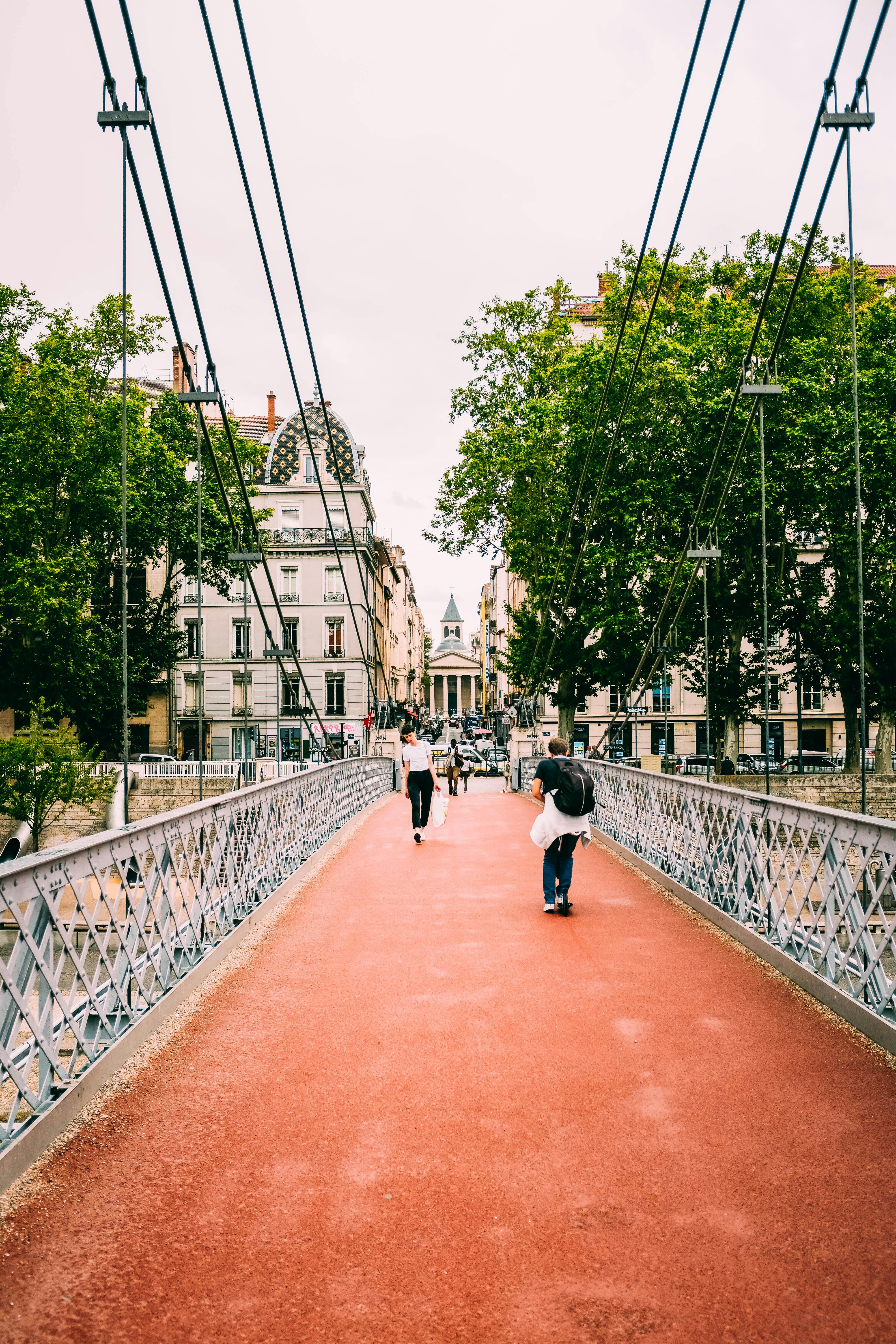 在欧洲城市充满活力的建筑间，人们走在风景如画的人行天桥上