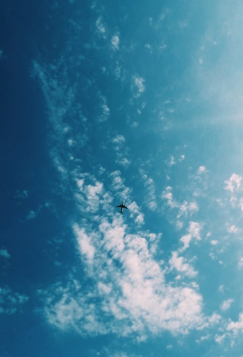 Low Angle Photo of Airplane Flying Under Sky