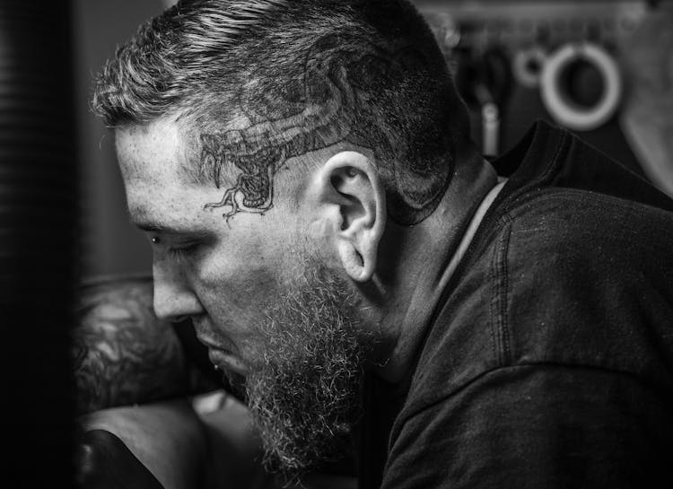 Close View Of Man With Beard And Cobra Tattoo On Side Of His Head