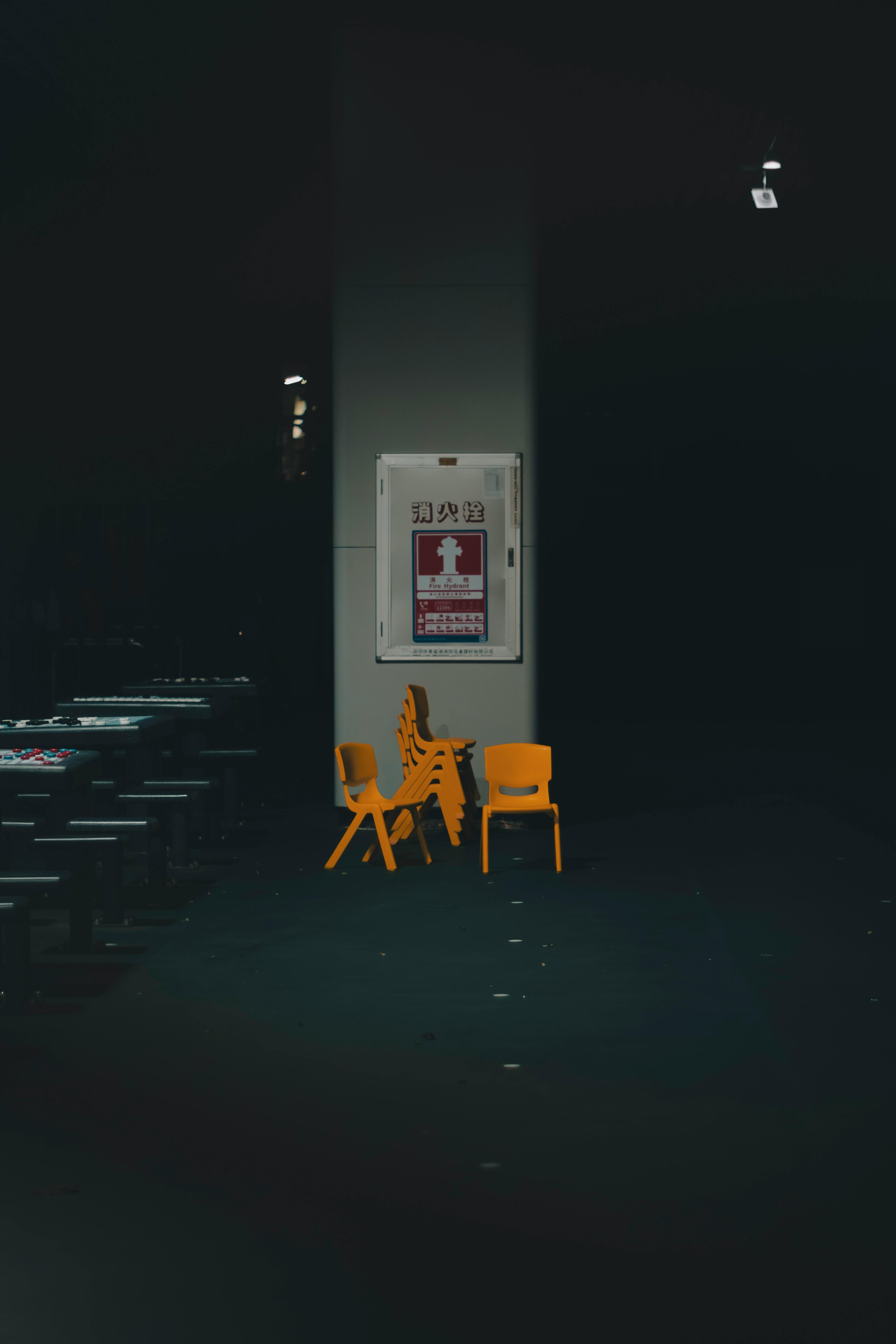 Free A moody subway station interior in Shenzhen with stacked yellow chairs and dim lighting. Stock Photo