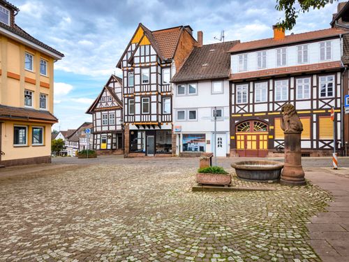 Free Quaint cobblestone square with traditional European architecture in a serene setting. Stock Photo