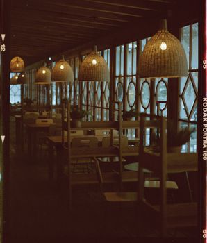 Dimly lit restaurant interior with wooden furnishings and hanging lamps creating a cozy atmosphere.