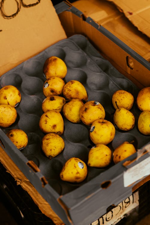 A box of yellow fruit sitting on top of a table