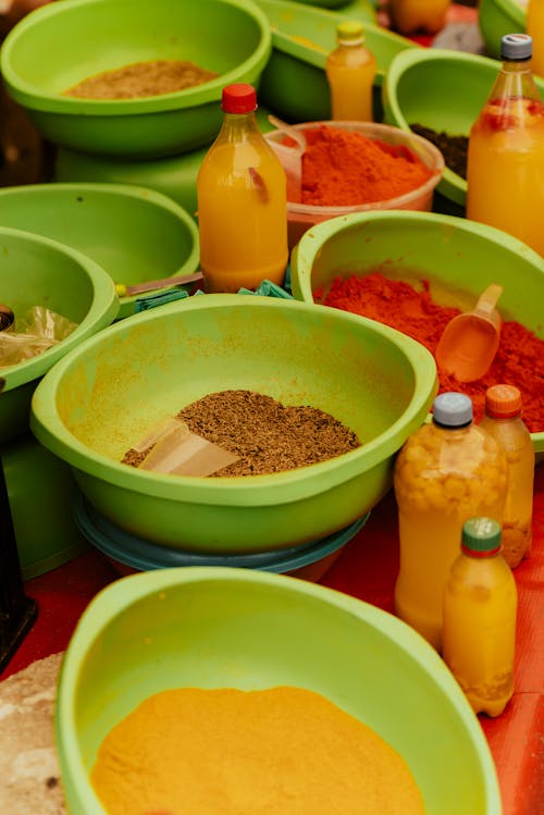 A table with bowls of different colored spices