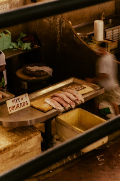 Free Fresh fish display with Dourada sign in dimly lit market setting. Stock Photo