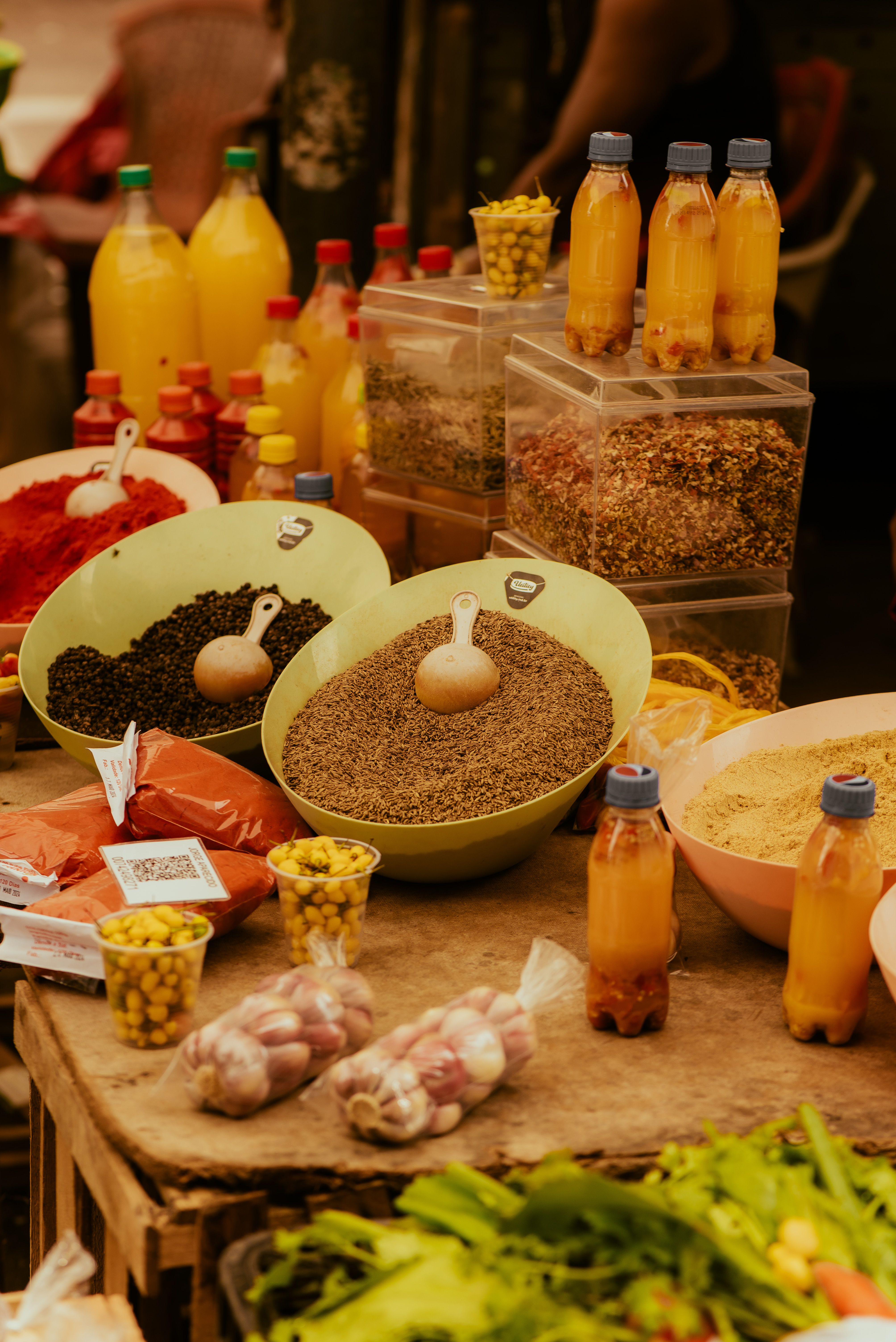 Colorful market scene featuring spices, fresh produce, and bottled juices displayed vibrantly.