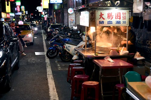 A street scene with a food stand and motorcycles