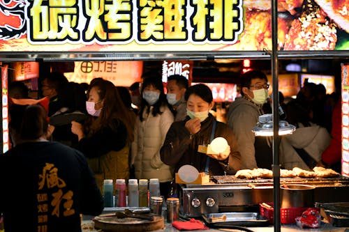 A man is standing in front of a food stand