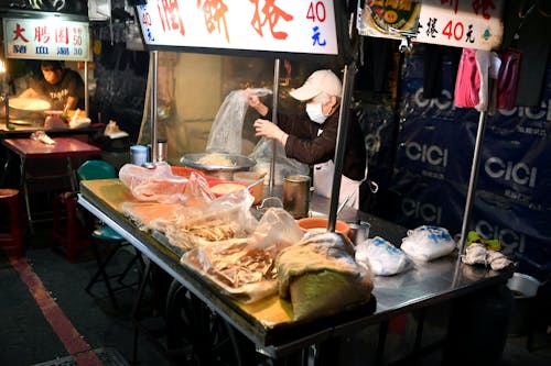 A woman is preparing food at a food stand