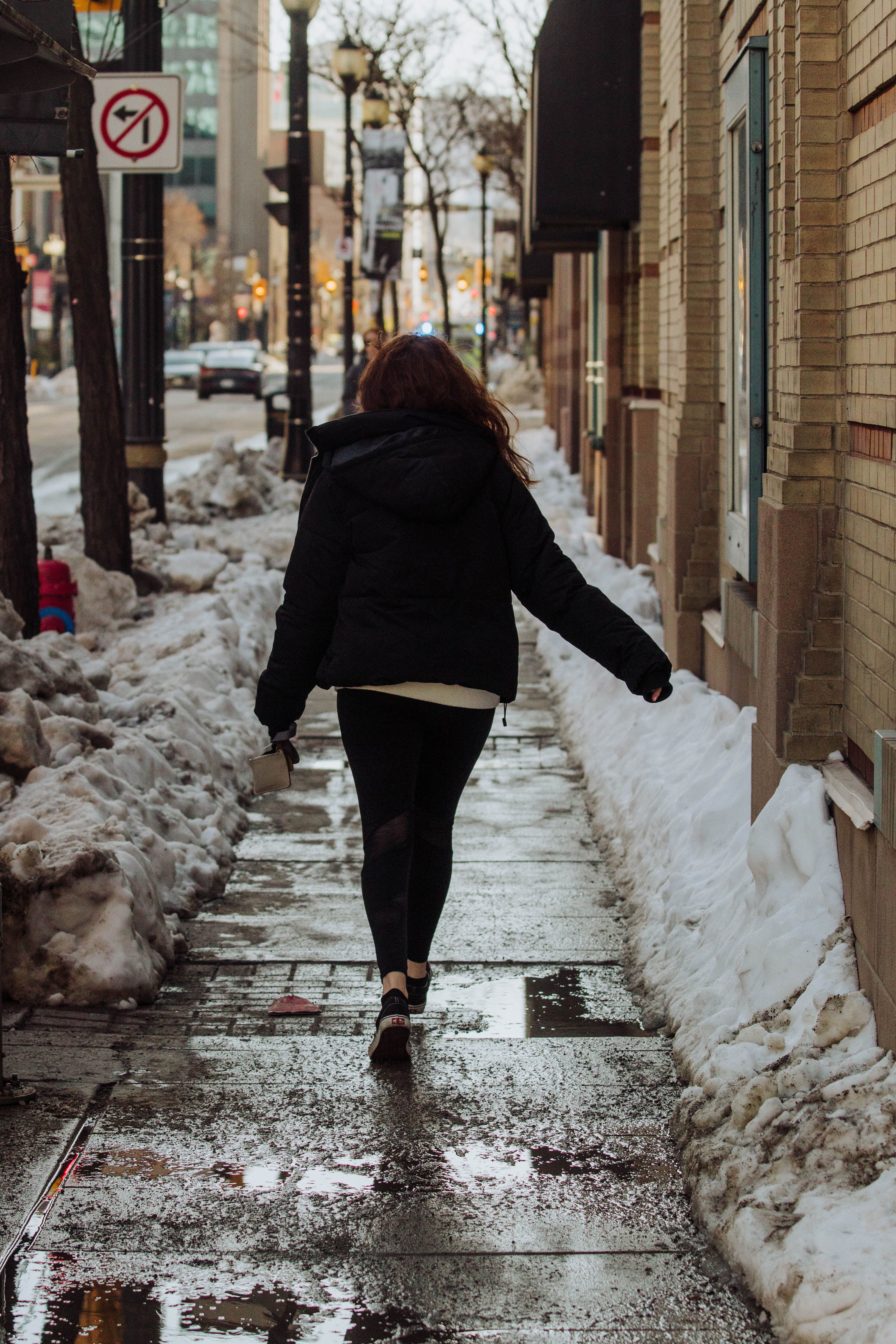 Back View of a Woman Walking an Urban Street · Free Stock Photo