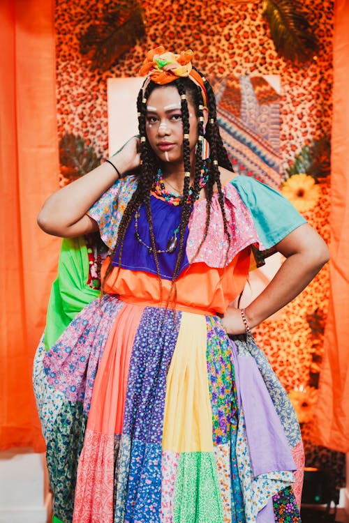 A woman in a colorful dress poses for a photo