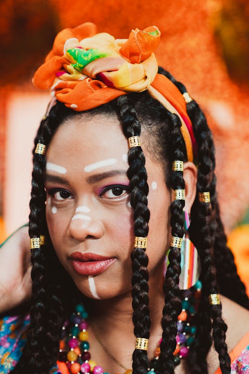 A woman with braids and colorful makeup