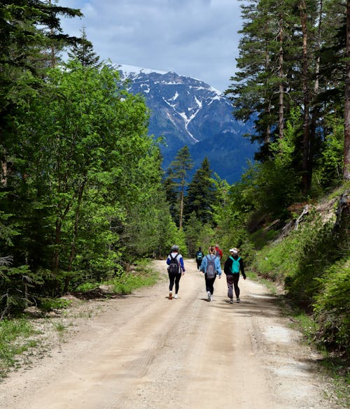 People walking down a dirt road in the mountains
