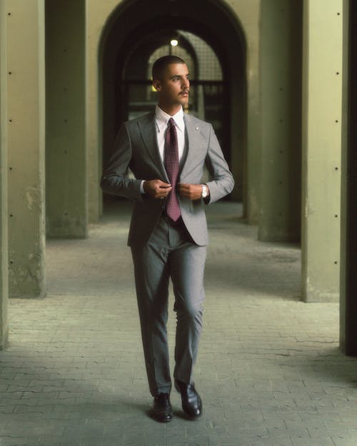 A man in a suit and tie walking through an archway