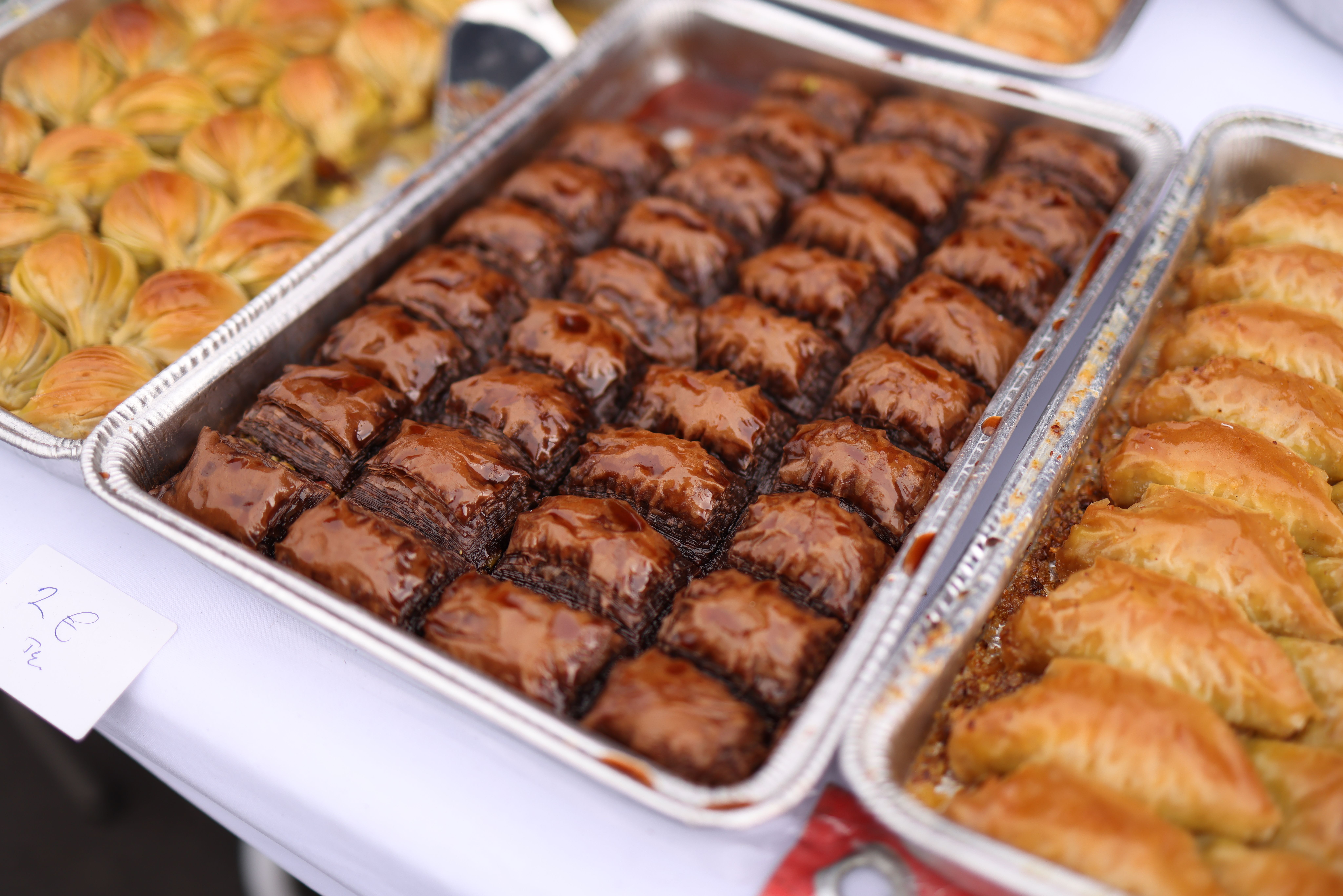 Flaky baklava pieces drizzled with honey syrup on a tray