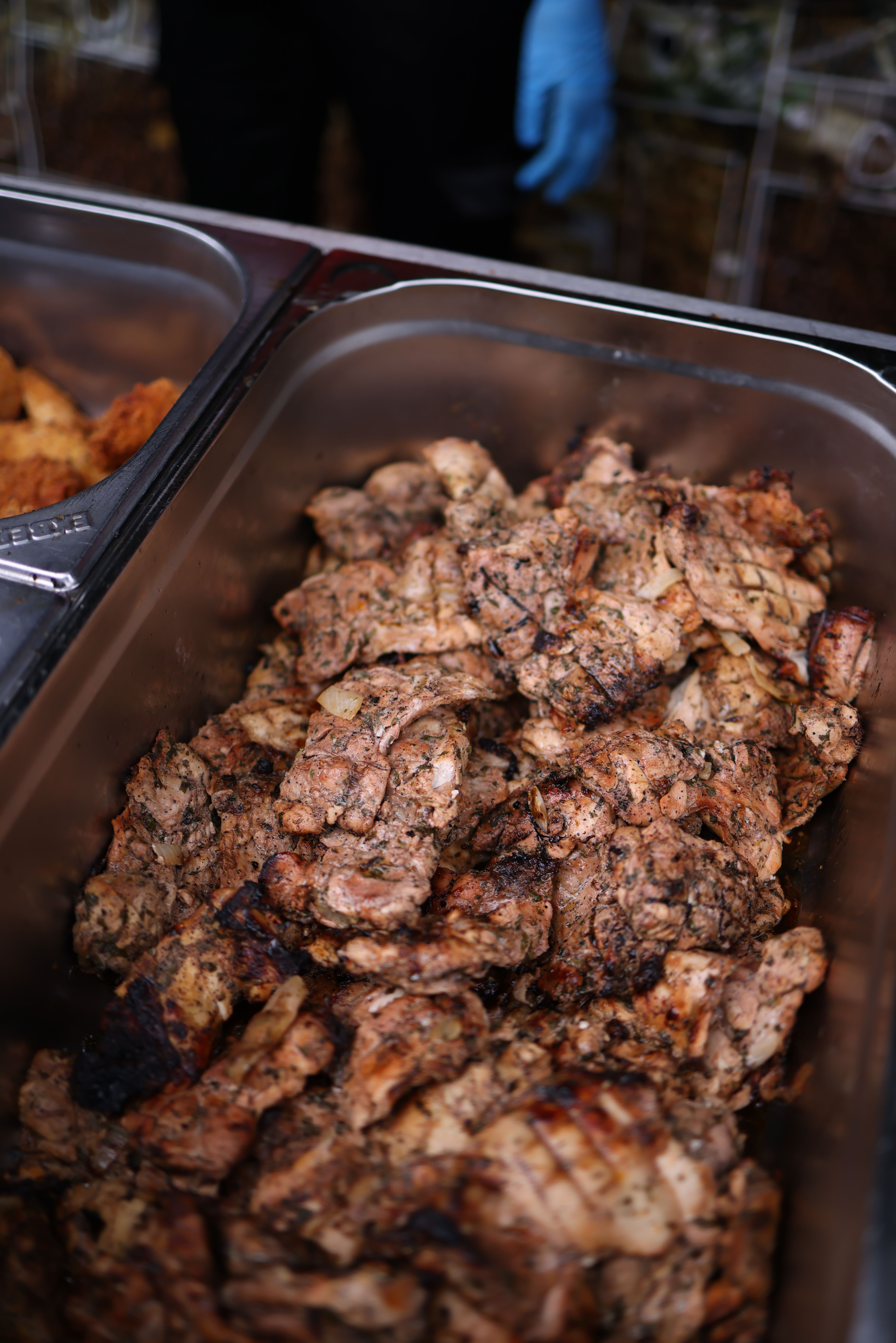 Appetizing grilled chicken in a buffet tray, perfect for restaurants or events.