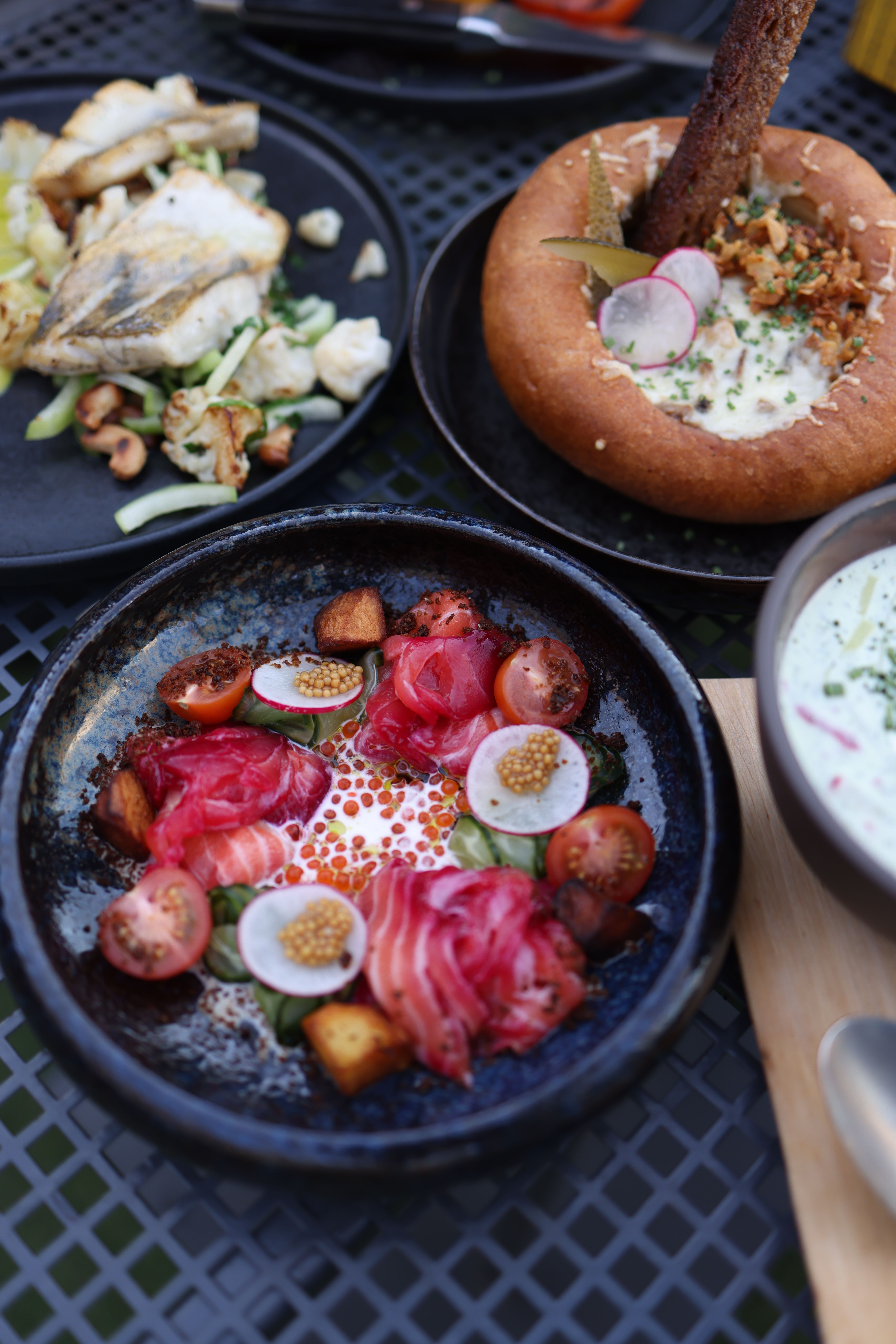 A gourmet seafood lunch featuring salmon, radishes, and caviar presented beautifully on plates.