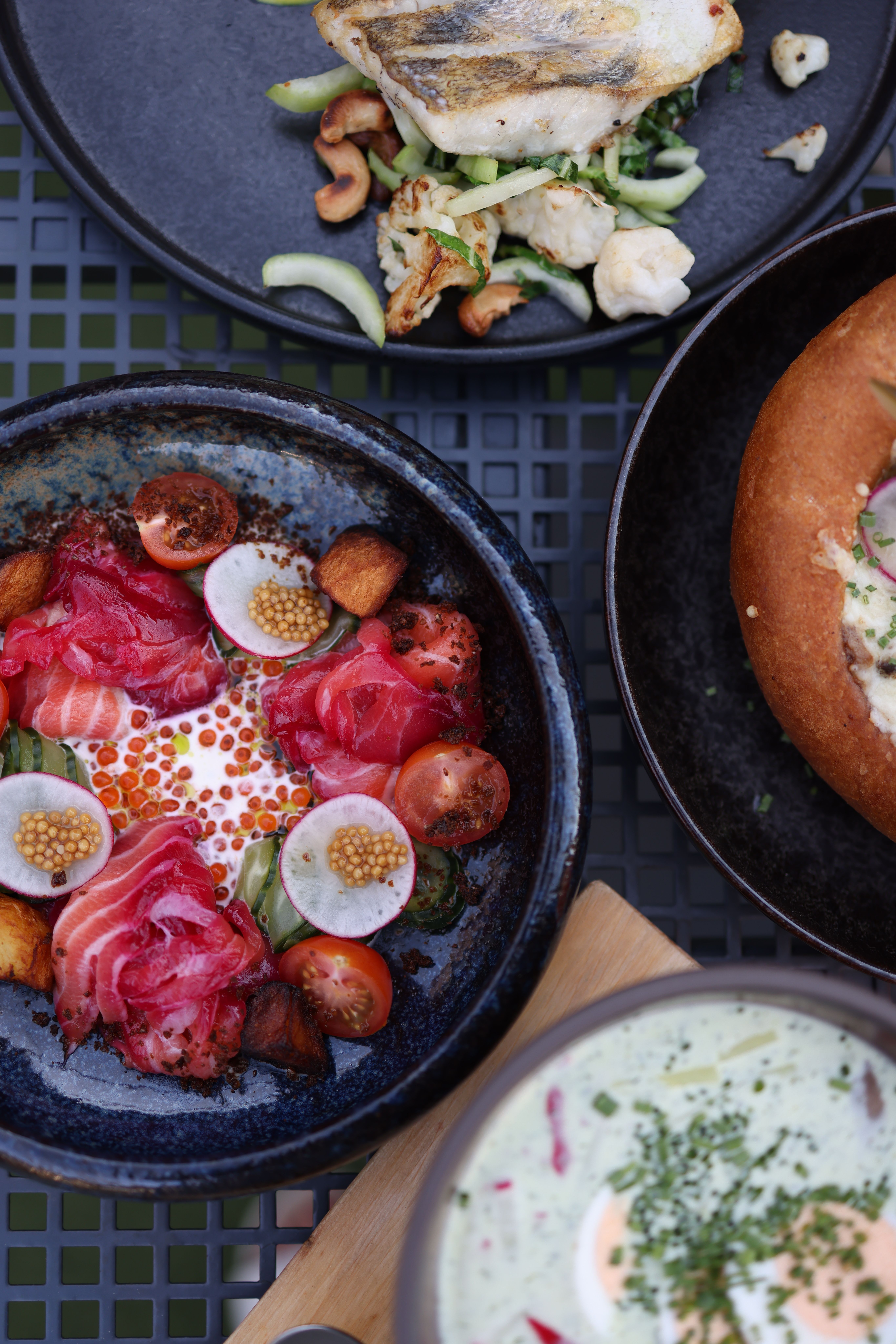 A variety of gourmet seafood and vegetable dishes beautifully presented on plates.
