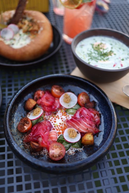 Free Indulge in a gourmet dish featuring beet cured salmon, radishes, and cherry tomatoes. Stock Photo