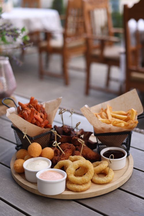 A wooden table with a plate of food and a basket of rings