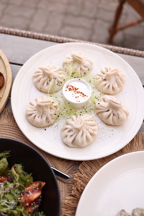 A plate of dumplings with salad and other food