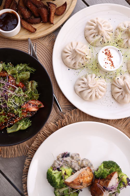 A table with two plates of food and a bowl of salad