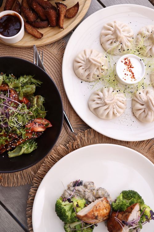 Free A top-down view of dumplings, salad, and broccoli chicken on a rustic table setting. Stock Photo