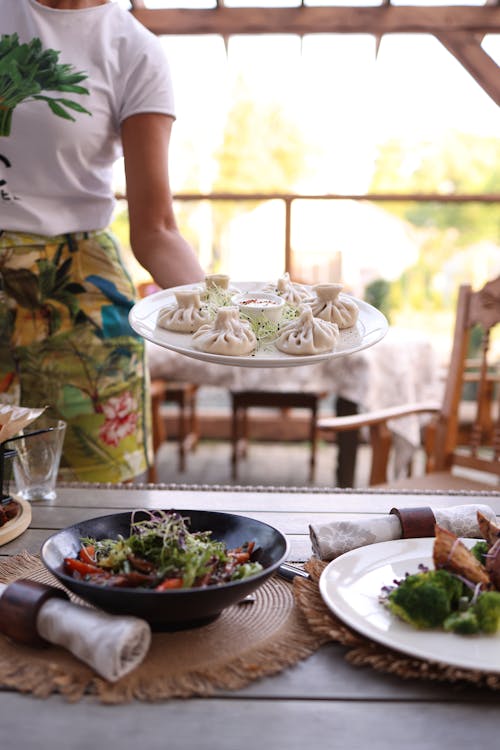 A woman holding a plate of food on a table