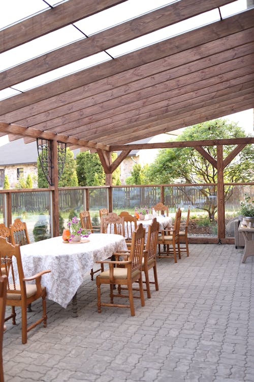 A patio with a table and chairs under a covered roof