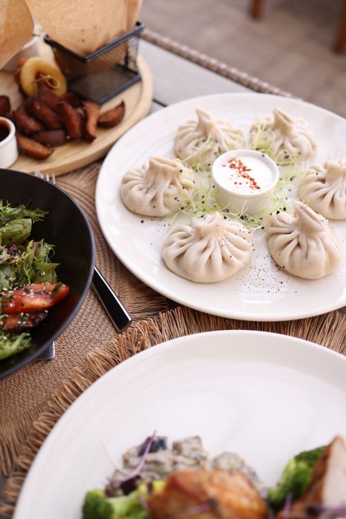 Free Close-up of gourmet dumplings served with sauce on a restaurant table set for a meal. Stock Photo