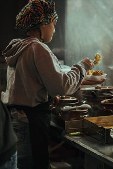 A chef in a cozy kitchen preparing a traditional dish with vibrant ingredients.