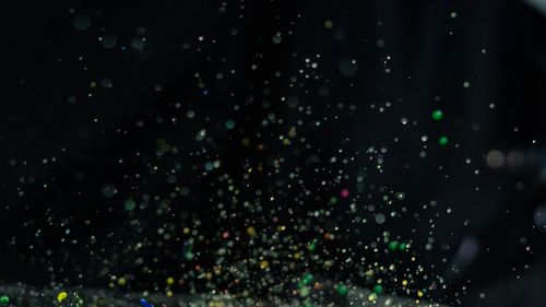 Free Vibrant multicolor paint splatter captured in motion with a dark backdrop, ideal for creative design. Stock Photo
