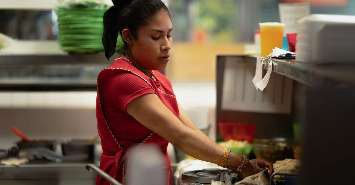 A woman in a vibrant kitchen in Ciudad de México expertly prepares traditional Mexican food.