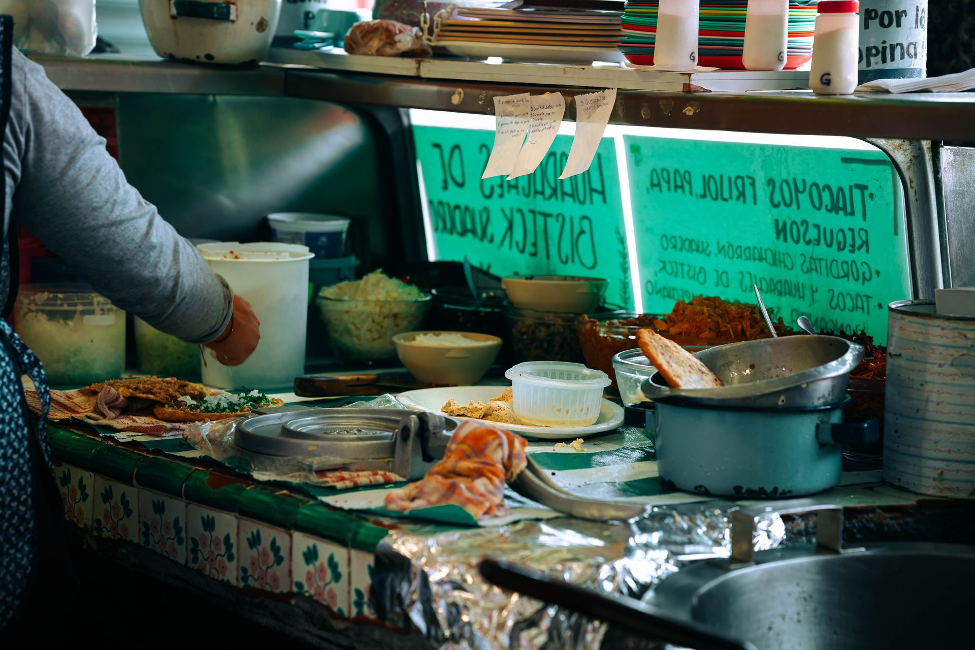 A bustling street food vendor preparing traditional Mexican dishes in Mexico City.