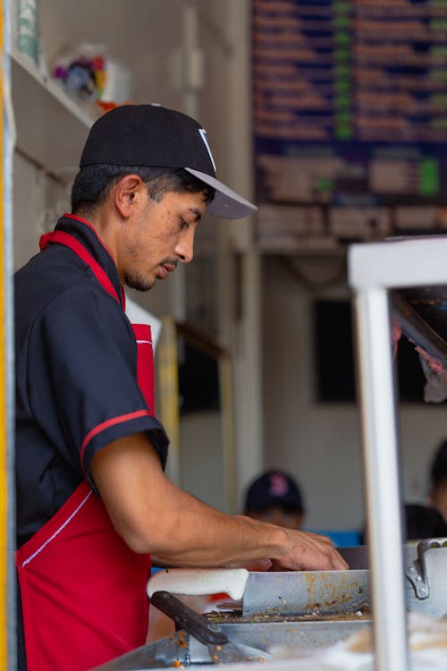 A man in a red and black shirt is preparing food