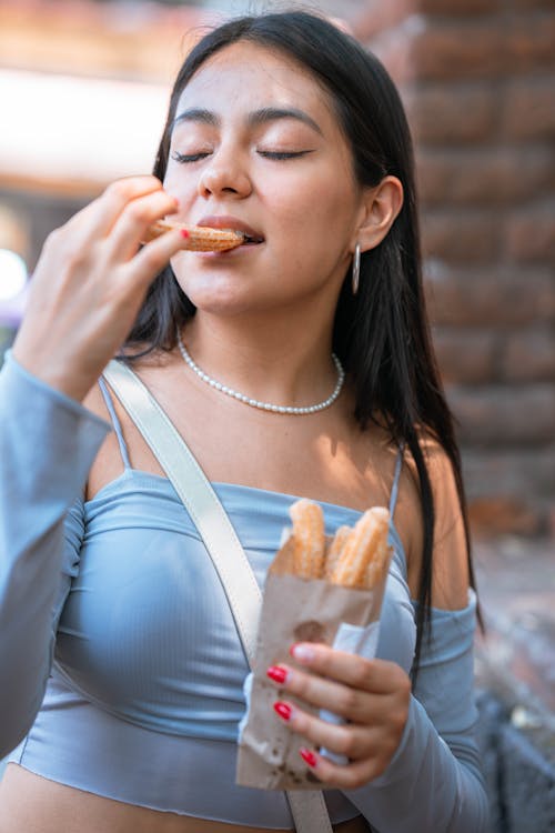 A woman eating a hot dog and french fries
