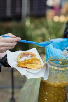 Close-up of tacos with salsa being prepared in Ciudad de México street market.