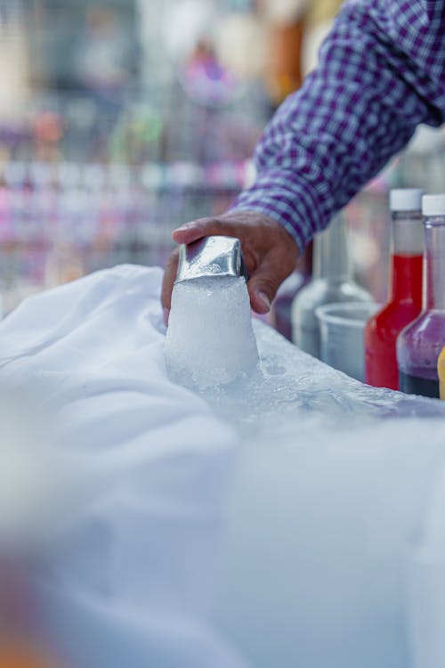 A man is holding a drink in front of a bar