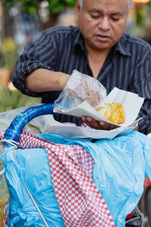 A man is eating food from a bag