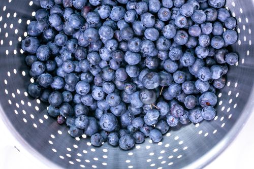 Free Top view of fresh blueberries in a metal strainer, highlighting their vibrant color and freshness. Stock Photo