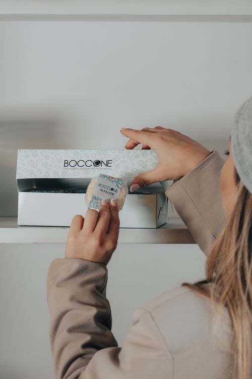 Free A woman opening a Boccone box in a store setting, focusing on packaging. Stock Photo