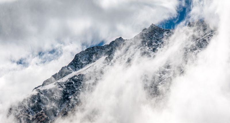 Snow-capped mountains behind a modern city skyline