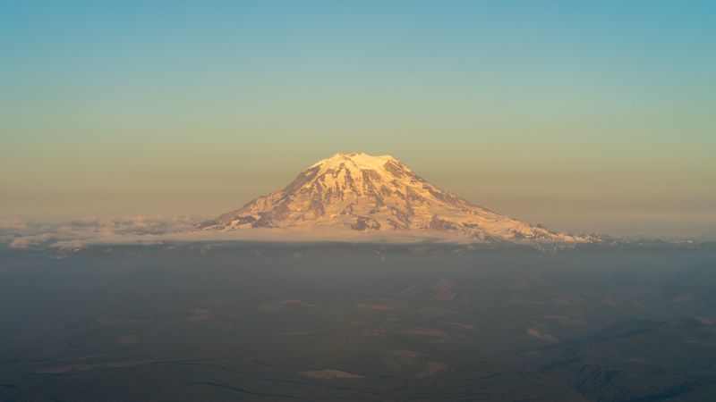 Snow-covered mountain peak rising above clouds