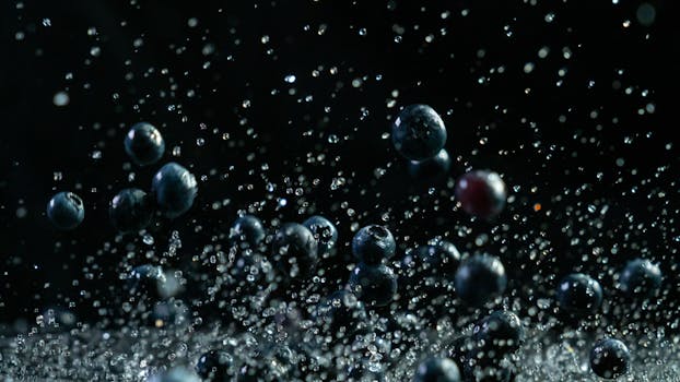 A dynamic close-up of fresh blueberries highlighted by a dramatic water splash with a dark background.