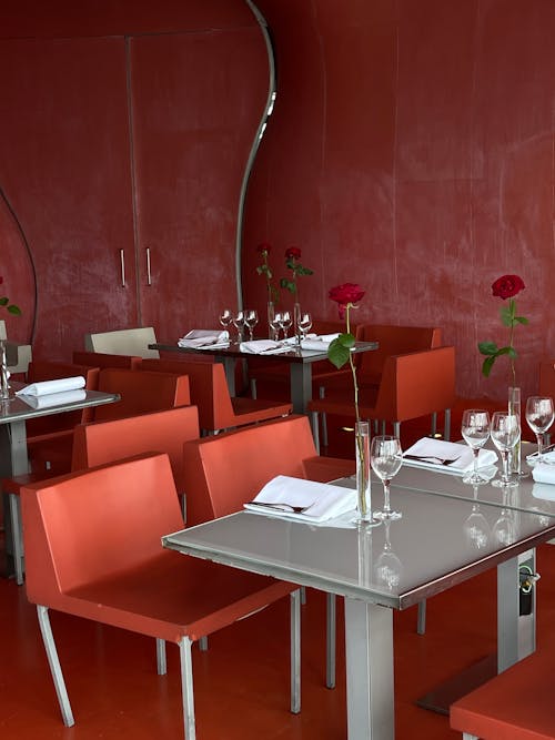 A restaurant with red walls and tables and chairs