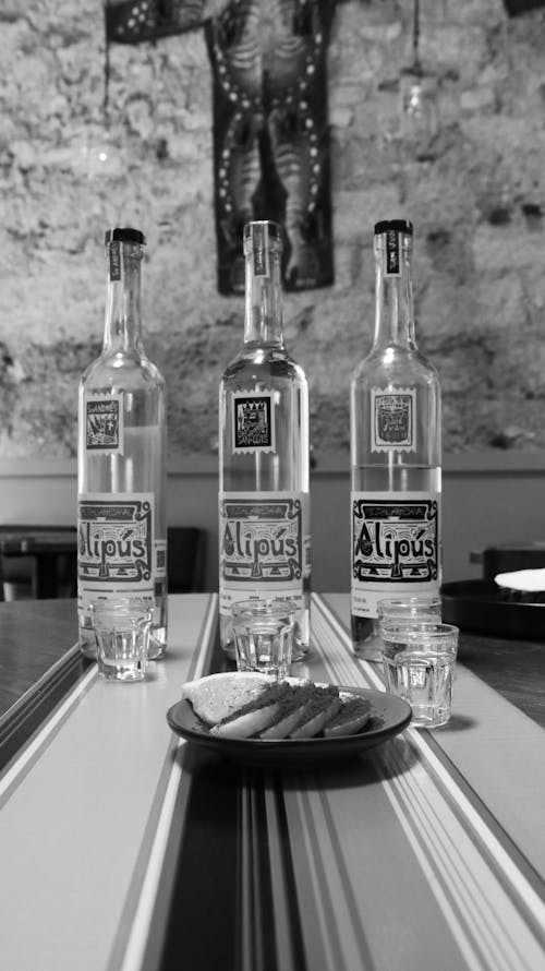 A black and white photo of three bottles of liquor