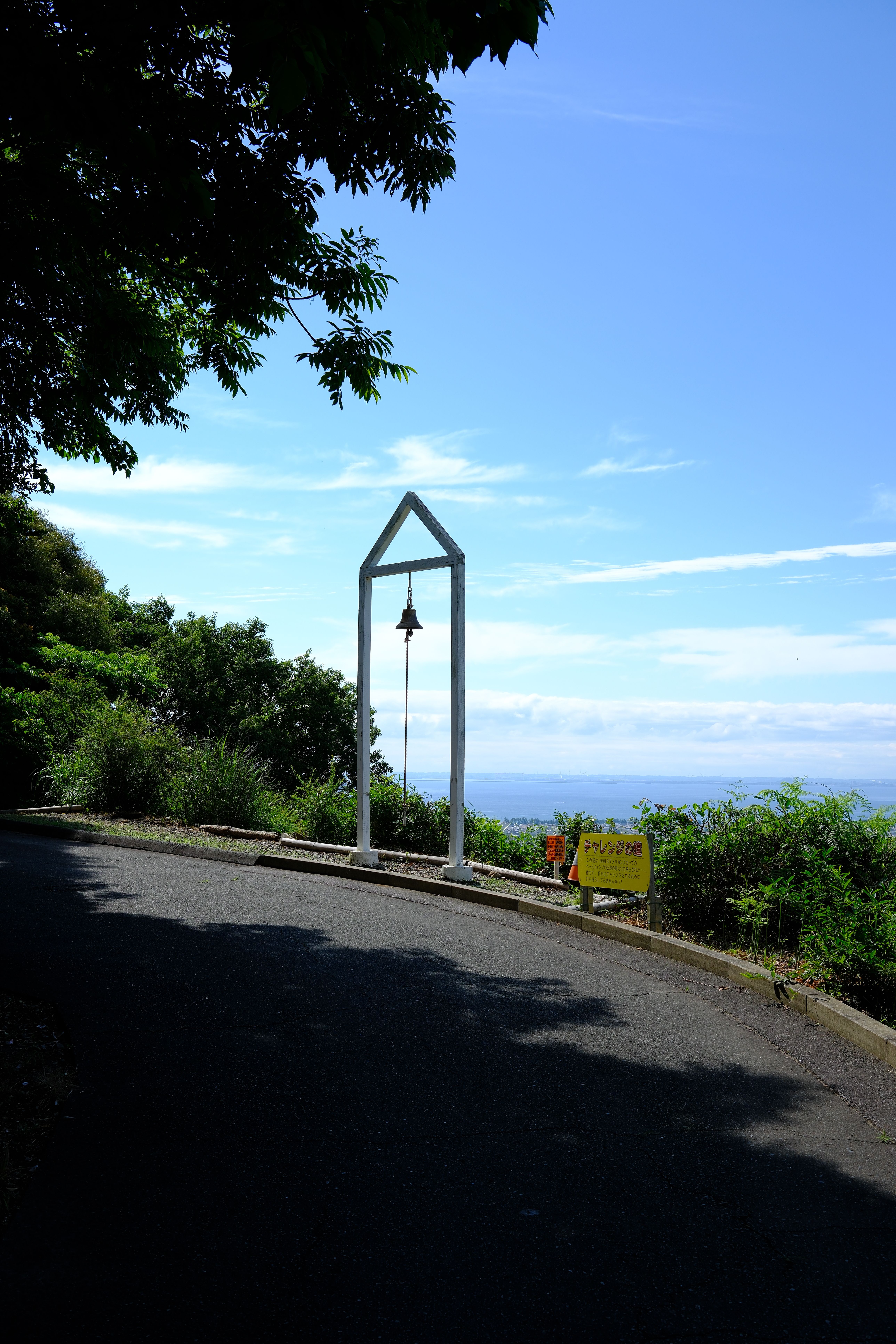 Tranquil view of a bell along a scenic coastal road in Gamagōri, Japan.